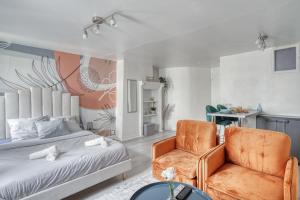 - une chambre avec un lit et une chaise dans l'établissement La Perle de Pontoise - studio proche Paris, à Pontoise