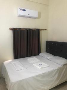 a bedroom with a white bed with a black curtain at Hotel Freedom Nagua in Nagua