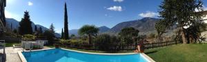 a swimming pool with a view of a mountain at Hotel Garni Hubertus in Tirolo