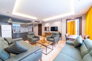 a living room with a couch and chairs and a kitchen at Garden Room Otel in Istanbul