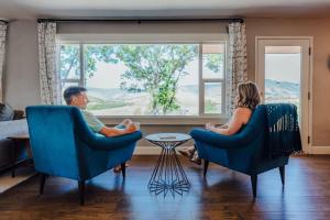 zwei Personen, die in einem Wohnzimmer auf Stühlen sitzen in der Unterkunft Expansive Views at The Crest House by Swank House in Ashland
