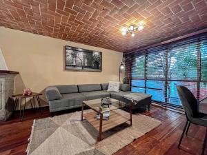 ein Wohnzimmer mit einem Sofa und einem Tisch in der Unterkunft Mi Zona Lodging Coyoacán in Mexiko-Stadt