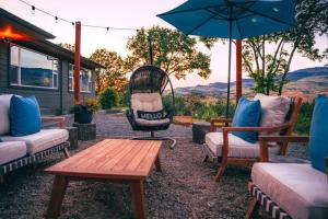 a patio with chairs and a table and an umbrella at Expansive Views at The Crest House by Swank House in Ashland