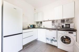 una cucina con armadi bianchi e una lavatrice/asciugatrice di Comfortable Home with Garden - 1BR6P - Vanves a Vanves