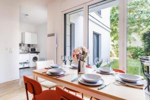 旺夫的住宿－Comfortable Home with Garden - 1BR6P - Vanves，一间带桌椅和大窗户的用餐室