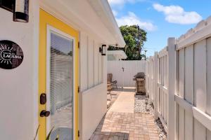 a walkway between two white buildings with a yellow door at Laguna @ Casa Del Sol in Fort Lauderdale
