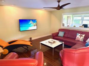 a living room with a red couch and a tv at Modern Luxury Beach House Kailua in Kailua