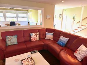 a living room with a brown leather couch with pillows at Modern Luxury Beach House Kailua in Kailua