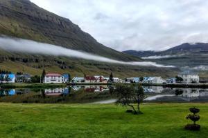 un pueblo en las montañas al lado de un cuerpo de agua en Nýlenda, en Seyðisfjörður