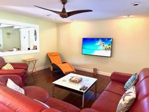 a living room with red furniture and a flat screen tv at Modern Luxury Beach House Kailua in Kailua