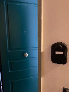 una porta blu con una cassetta della posta nera sul muro di La Cupola 129 a Olbia
