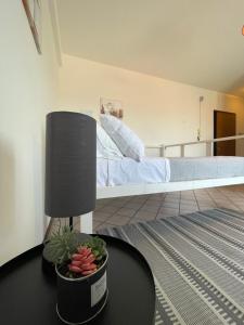 una camera da letto con un letto e un tavolo con una pianta di La Cupola 129 a Olbia