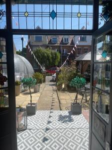 洛斯托夫特的住宿－月桂樹別墅酒店，享有带盆栽植物和旗帜的庭院的窗户