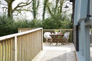 eine Terrasse mit einem Tisch und Stühlen auf einem Zaun in der Unterkunft Yew Tree Farm Stable, Worlingworth in Worlingworth