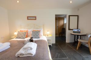 um quarto com 2 camas, uma secretária e um espelho. em Yew Tree Farm Stable, Worlingworth em Worlingworth