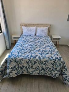 ein Schlafzimmer mit einem Bett mit einer blau-weißen Bettdecke in der Unterkunft Pueblo Townhouse By Monte vista in Puerto Peñasco + 4 Fotos
