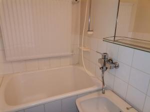 y baño con bañera blanca y lavamanos. en Budget housing en Kouvola