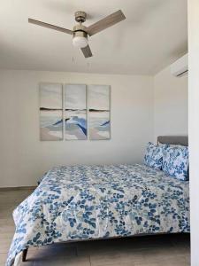 ein Schlafzimmer mit einem Bett und drei Gemälden an der Wand in der Unterkunft Pueblo Townhouse By Monte vista in Puerto Peñasco