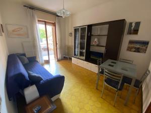 een woonkamer met een blauwe bank en een tafel bij Appartamento a due passi dal mare! in Borghetto Santo Spirito