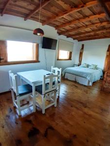Schlafzimmer mit einem Bett, einem Tisch und Stühlen in der Unterkunft La Cabaña de Sofi in Tandil