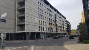 a tall building on a city street with cars parked at Boznicza Old Town LUX Apartment, self check-in 24h, free parking in Poznań
