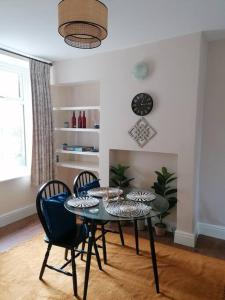 a dining room with a table and chairs and a clock at Miller's Cottage in Lancaster in Lancaster