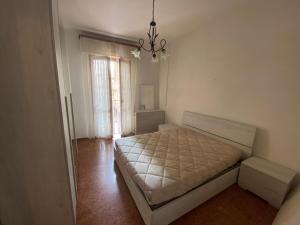 een slaapkamer met een bed en een kroonluchter bij Appartamento a due passi dal mare! in Borghetto Santo Spirito
