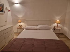 una camera da letto con un grande letto con due lampade su due tavoli di Solis Domus - Aurora a Ostuni