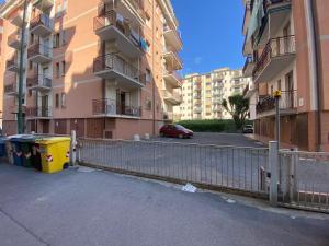 een parkeerplaats met een hek voor een gebouw bij Appartamento a due passi dal mare! in Borghetto Santo Spirito