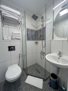a bathroom with a shower and a toilet and a sink at Amber Hotel in Sarajevo