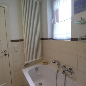 a bathroom with a white radiator and a bath tub at Omas Linde in Brandenburg an der Havel