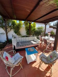 un patio con tavolo, panca e sedie. di Villa Lola 14 a Chiclana de la Frontera