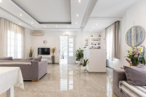 Una sala de estar con un sofá y un televisor. en Sun Beach Hotel, en Naxos Chora
