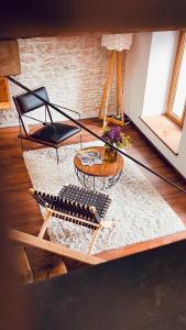 a living room with a table and a chair at Domaine du Pré-Saint-Georges in Taintrux