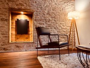 une chaise dans une pièce avec un mur en briques dans l'établissement Domaine du Pré-Saint-Georges, à Taintrux