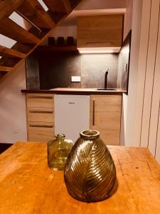 a metal vase sitting on a wooden table in a kitchen at Domaine du Pré-Saint-Georges in Taintrux