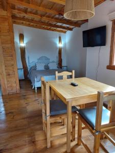 ein Esszimmer mit einem Tisch und einem Bett in der Unterkunft La Cabaña de Sofi in Tandil