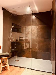 La salle de bains est pourvue d'une douche en verre et d'un lavabo. dans l'établissement Domaine du Pré-Saint-Georges, à Taintrux