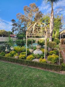 un jardín con cenador en un patio en Villa Rose Cottages en Bloemfontein
