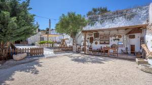 a house with a fence in front of a yard at Emilia's Little Farmhouses in Agii Anargiri Milos