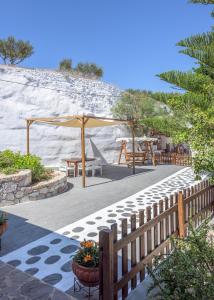 a patio with a wooden fence and a table and chairs at Emilia's Little Farmhouses in Agii Anargiri Milos
