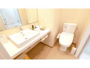 a bathroom with a sink and a toilet and a mirror at La'gent Hotel Okinawa Chatan Hotel and Hostel - Vacation STAY 59138v in Fuenzan