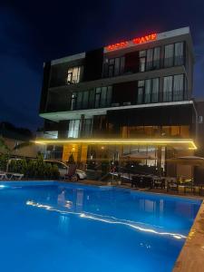 a hotel with a swimming pool in front of a building at Wave-ტალღა in Kobuleti