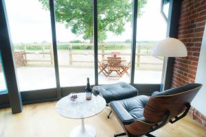 uma sala de estar com um sofá e uma mesa com uma garrafa de vinho em The Seed Store, High Ash Farm em Peasenhall