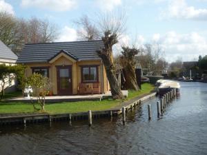 a small house on the side of a river at Cottage Nieuwkoop in Nieuwkoop