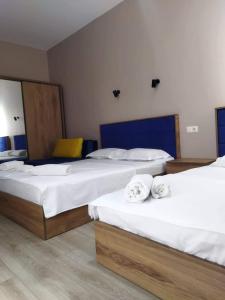 a bedroom with three beds with towels on them at Wave-ტალღა in Kobuleti