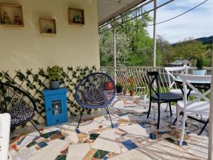 a patio with chairs and a table on a mosaic floor at Racha guest house MERO in Ambrolauri