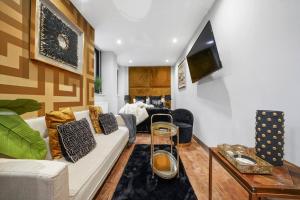 a living room with a couch and a table at Platinum Gold Court Modern Apartment in Kent