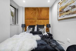 een slaapkamer met een groot bed en een witte deken bij Platinum Gold Court Modern Apartment in Kent