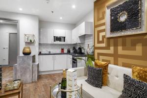 a living room with a couch and a kitchen at Platinum Gold Court Modern Apartment in Kent